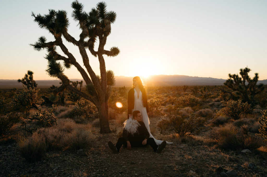 Couple posing in front of a sunset in Joshua Tree National Park.