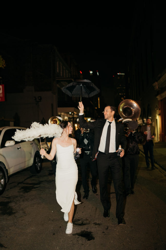 Second line band leading couple down the streets after their wedding in New Orleans 