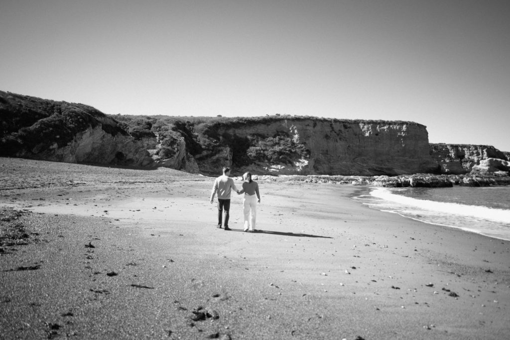 Couple in love walking down the beach in southern California 