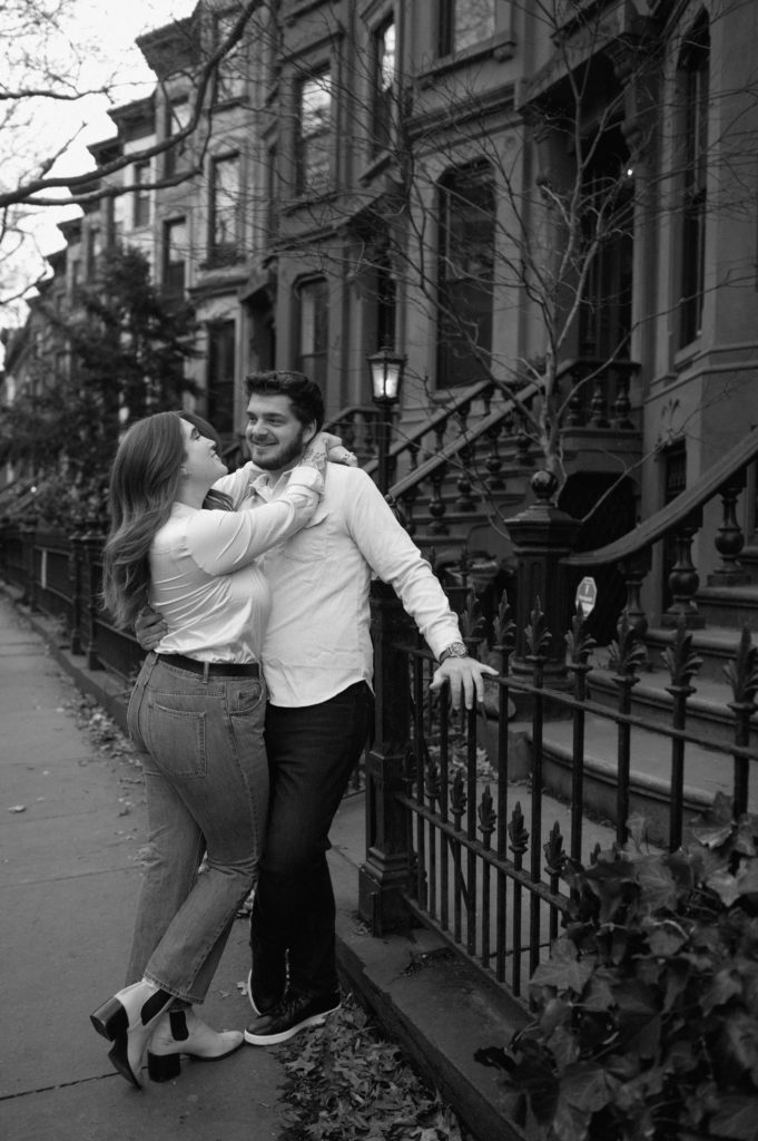 Black and white picture of couple near brownstones in Brooklyn