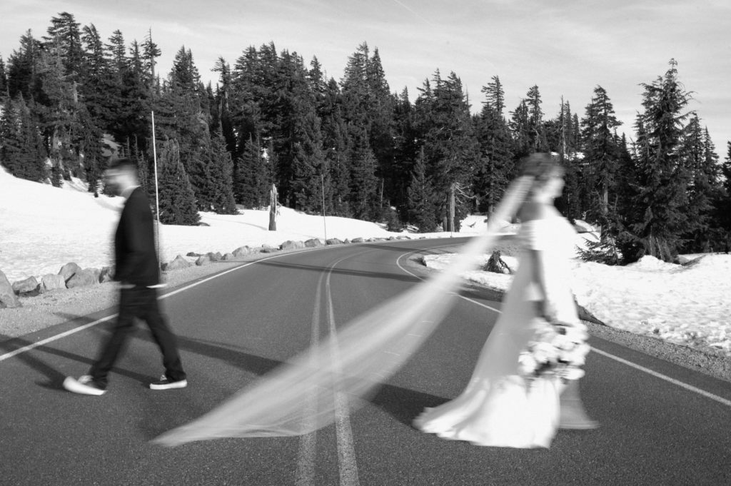 Couple walking across the road in Crater Lake National Park 