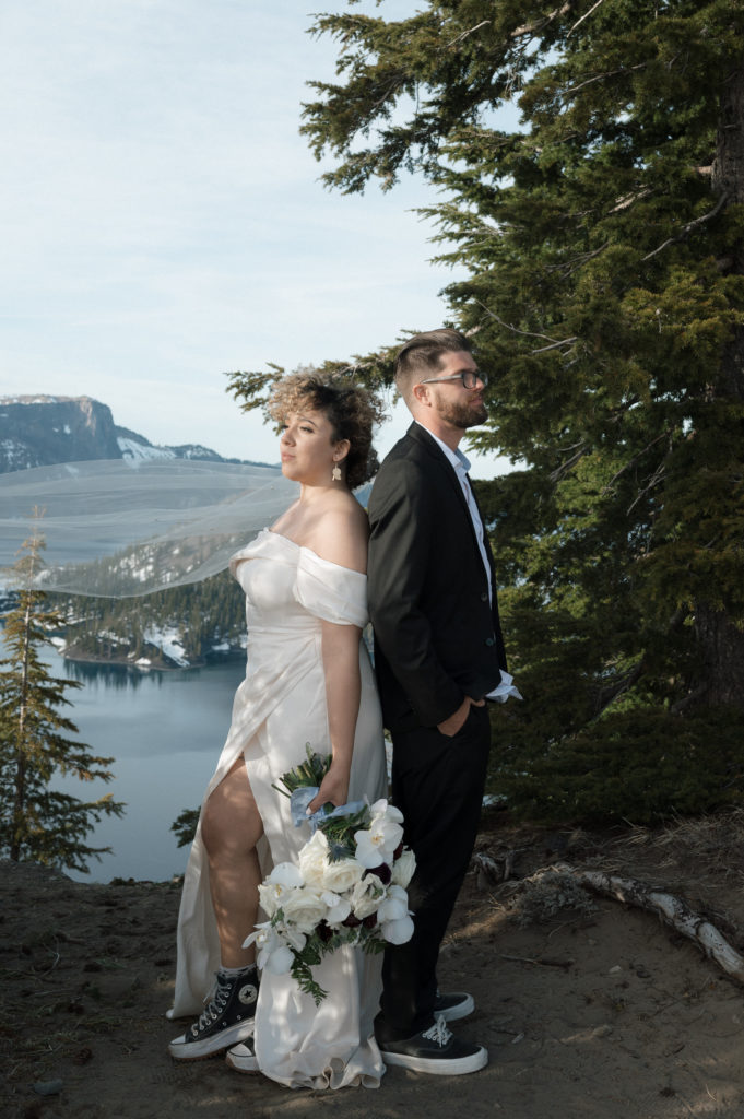 Couple posing after their elopement in front of Crate Lake in Oregon.