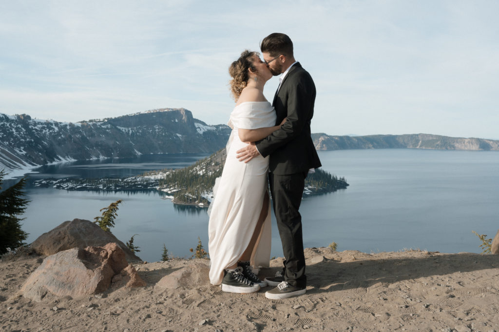 Couple kissing in front of Crater Lake National Park after eloping.