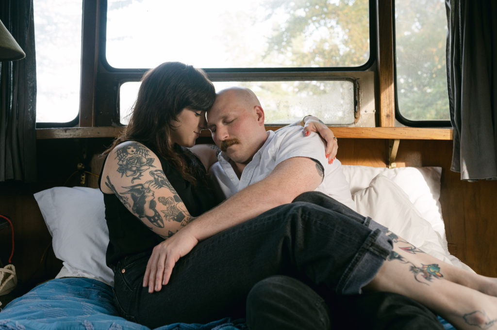 Couple snuggled up in bed in vintage camper in Sou'wester lodge in Seaview, Washington