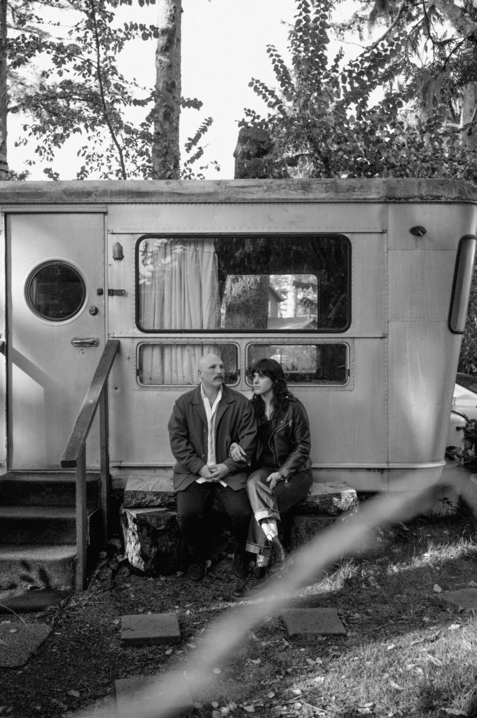 Couple sitting in front of vintage camper in Sou'wester lodge in Seaview