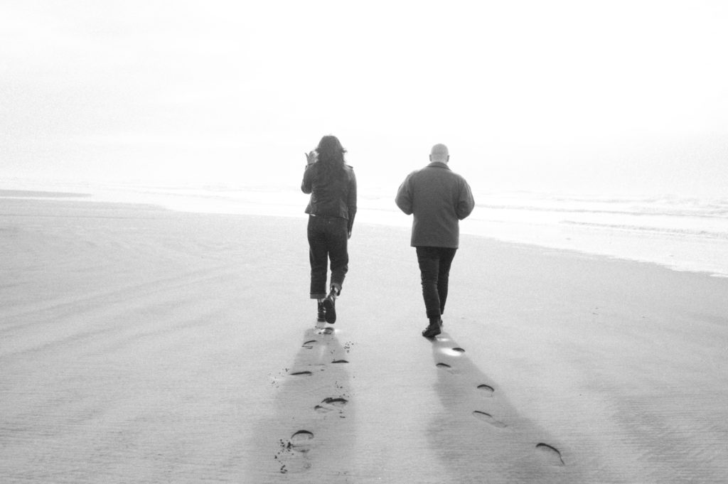 Black and white image of couple walking on the beach in Seaview, Washington 