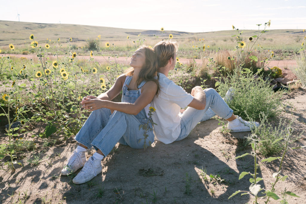 Couple siting in front of sunflowers 