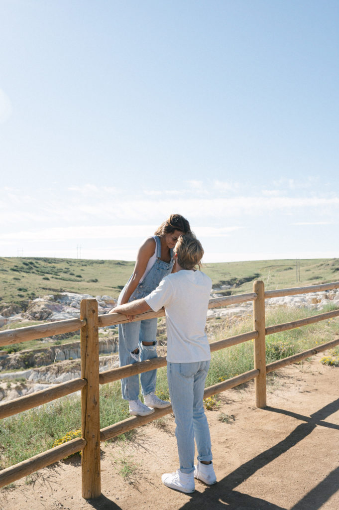 Couple kissing while standing on a fence 
