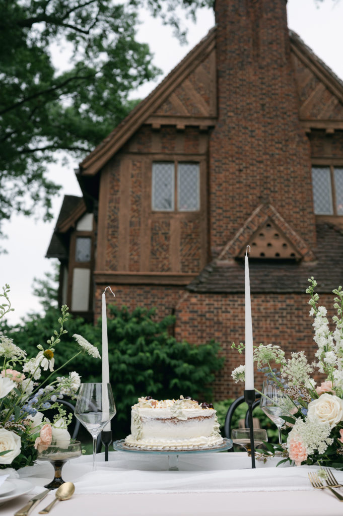 Italiann Soiree wedding cake in front of Pinecroft Mansion in Cincinnati, Ohio