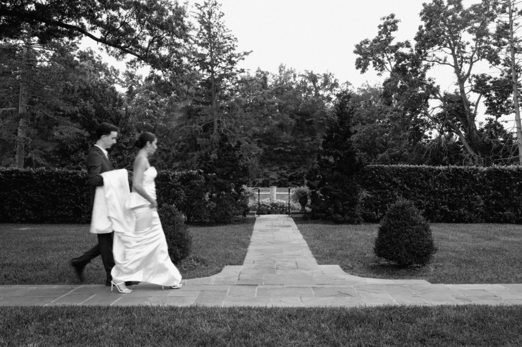 Black and white motion blur image of couple walking on a pathway.