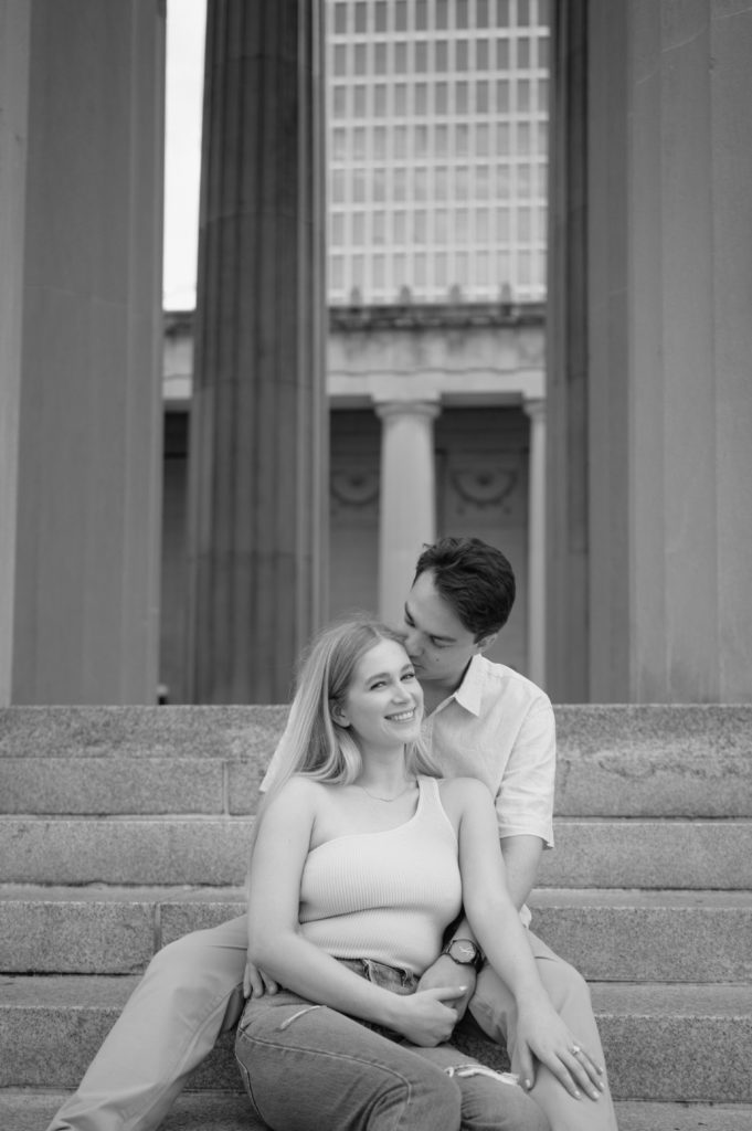 Future bride and groom sitting on the stairs of The War Memorial Building for their engagement photos in Nashville