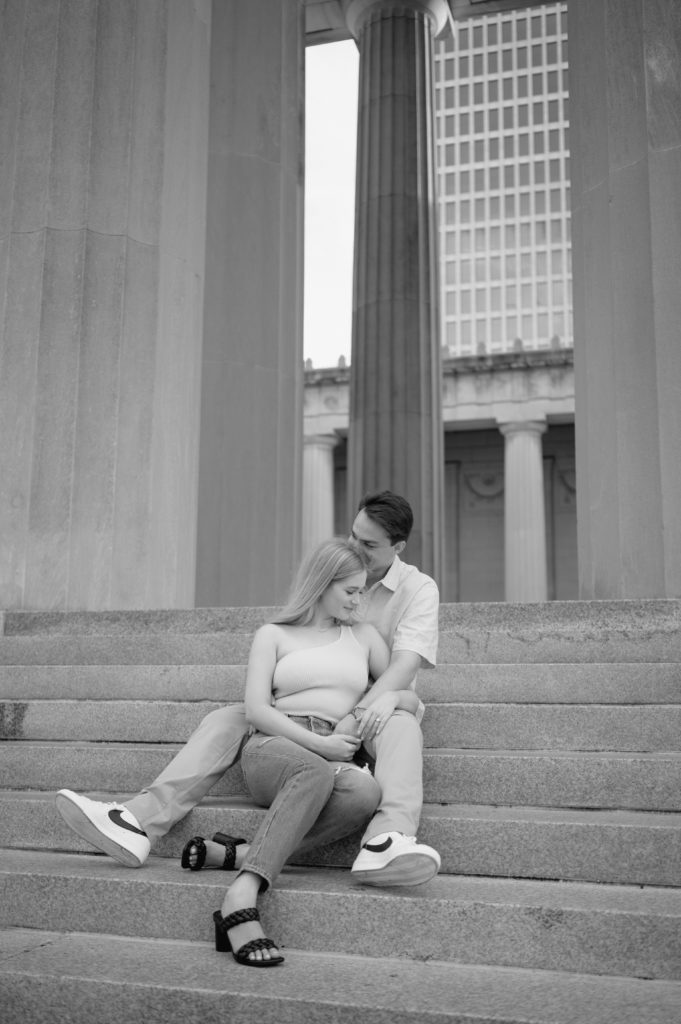 Future bride and groom sitting on the stairs of The War Memorial Building for their engagement photos.