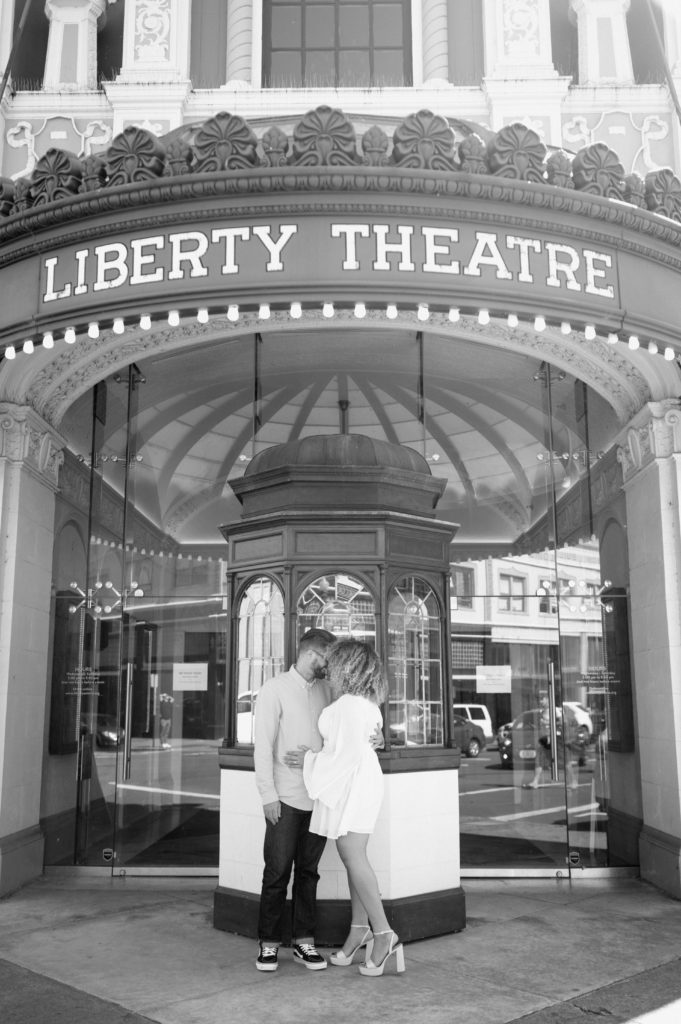 Couple posing in front of Liberty Theatre in Astoria, Oregon 