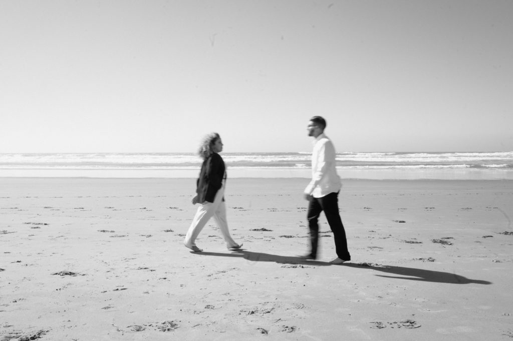Black and white motion blur image of couple on the coast.