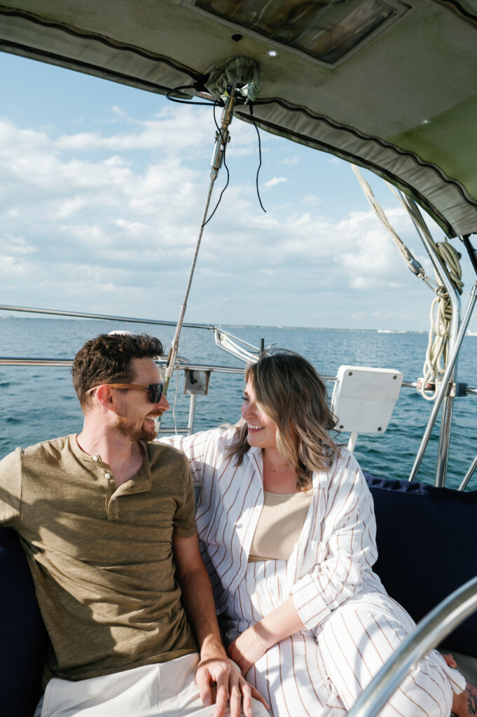 Couple laughing while sitting on their sailboat 