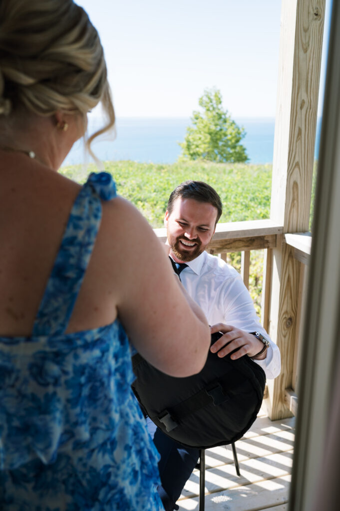 Brides sister giving groom his gift on the balcony with Lake Michigan in the background