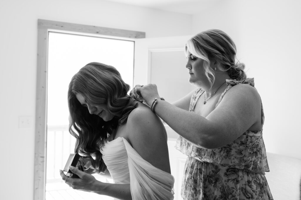 Bride's sister helping her get ready 