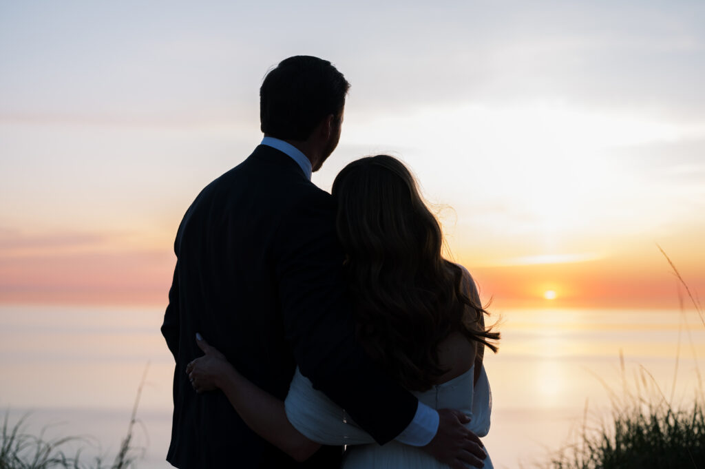 Couple watching the sunset over Lake Michigan on their wedding day