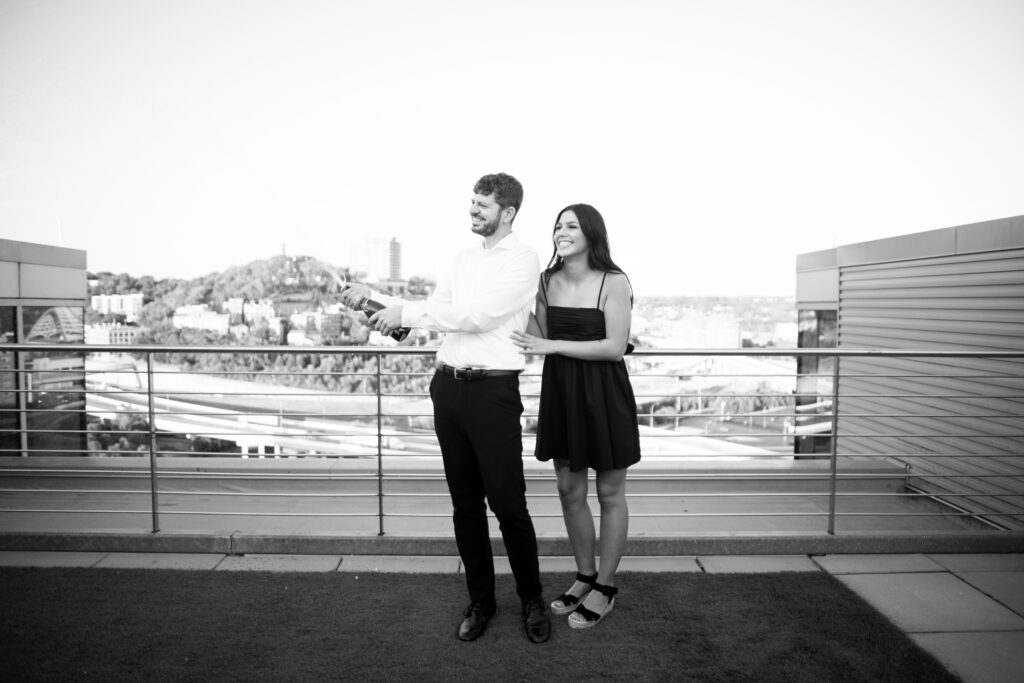 Couple popping champagne on a rooftop in Downtown Cincinnati