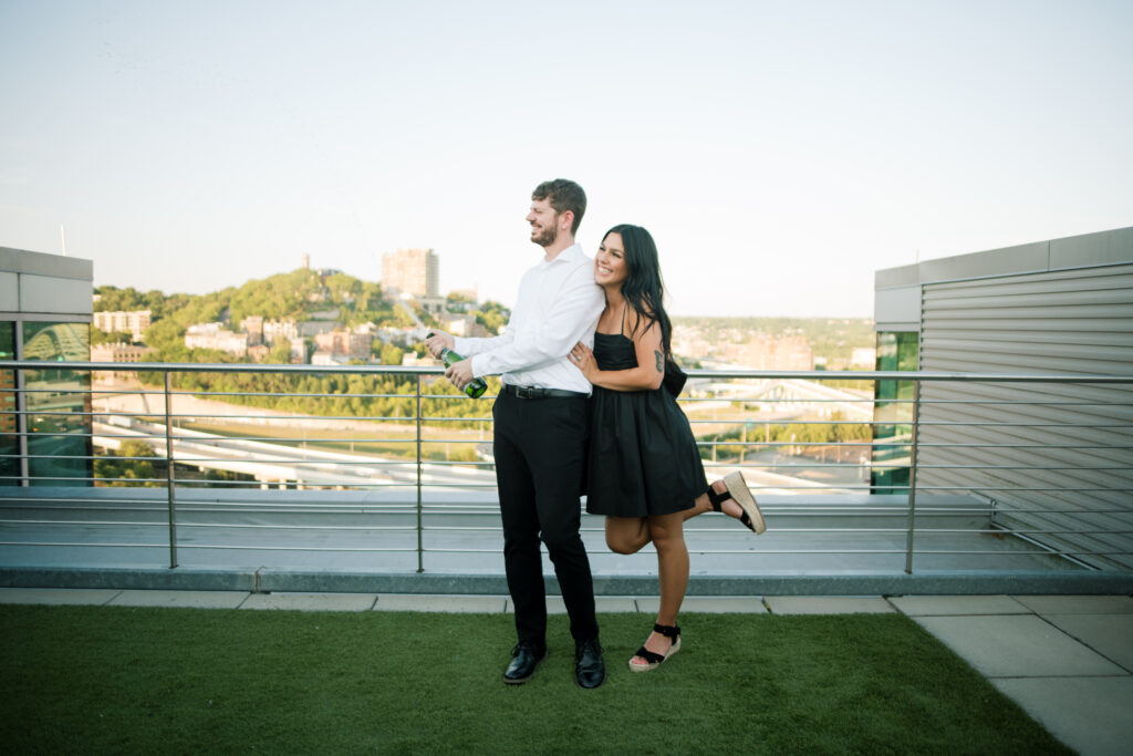 Couple popping champagne on a rooftop in Downtown Cincinnati
