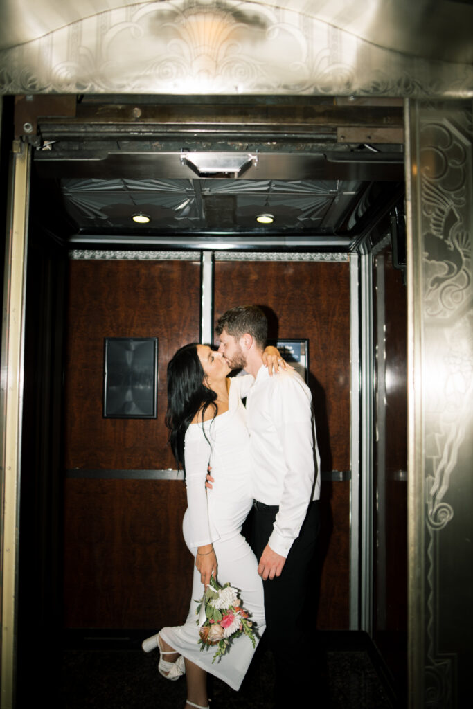 Flash photo of couple kissing in an elevator from engagement photos in The Hilton Netherlands Plaza in Downtown Cincinnati, OH