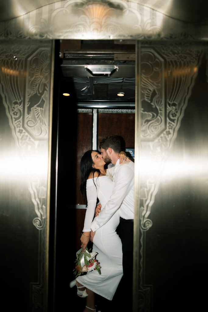 Flash photo of couple kissing in an elevator from engagement photos in The Hilton Netherlands Plaza in Downtown Cincinnati, OH