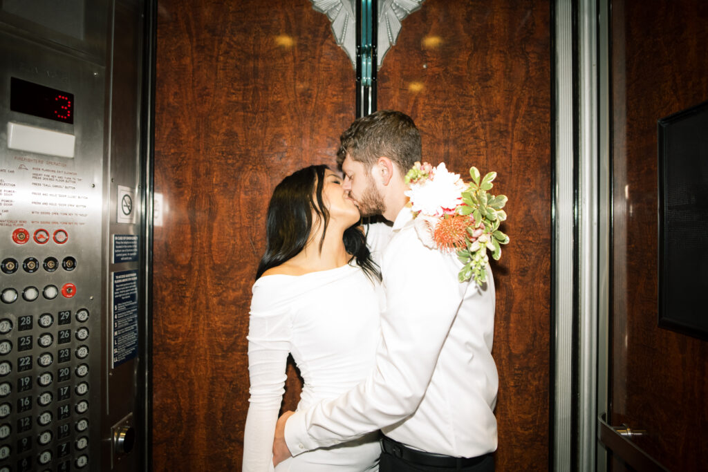 Flash photo of couple kissing in an elevator 