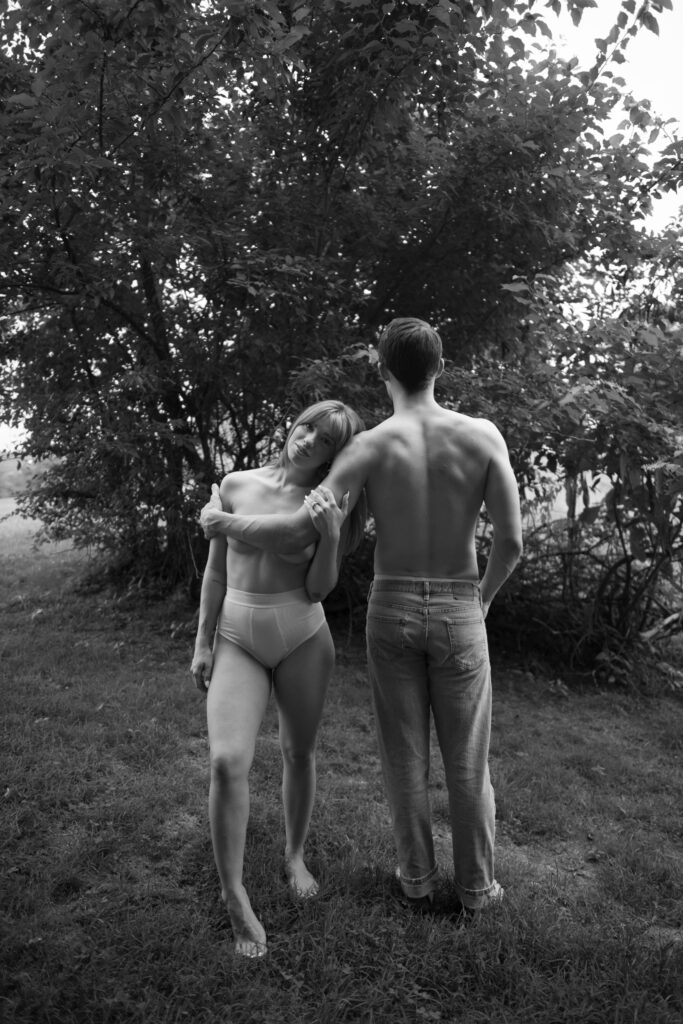 Black and white image of model couple posing shirtless in Tennessee 
