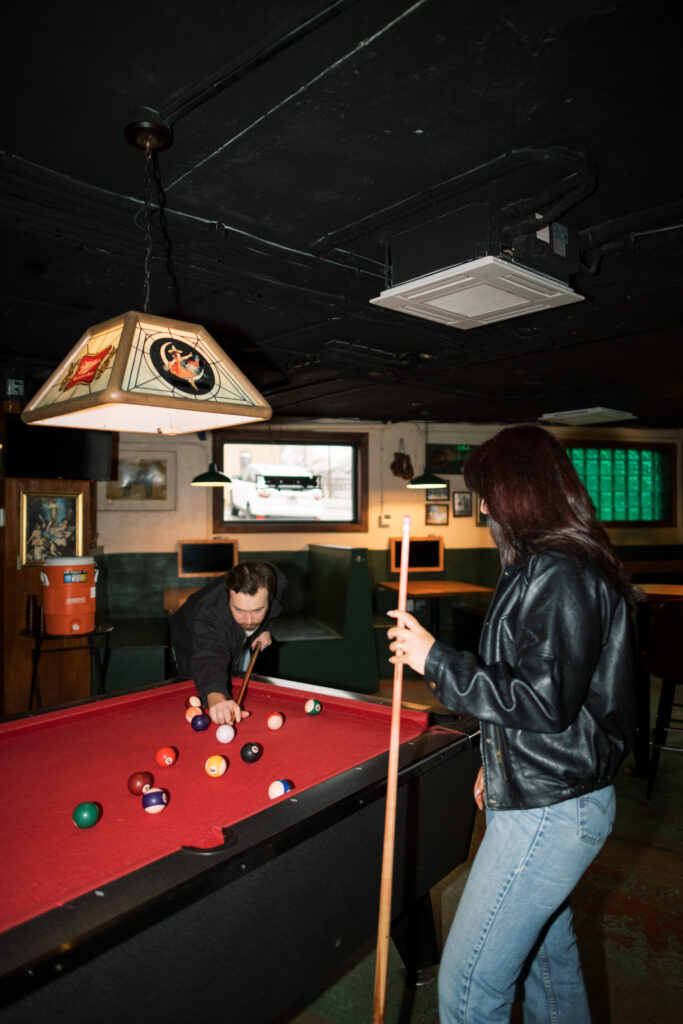 Engagement session at a bar with a pool table