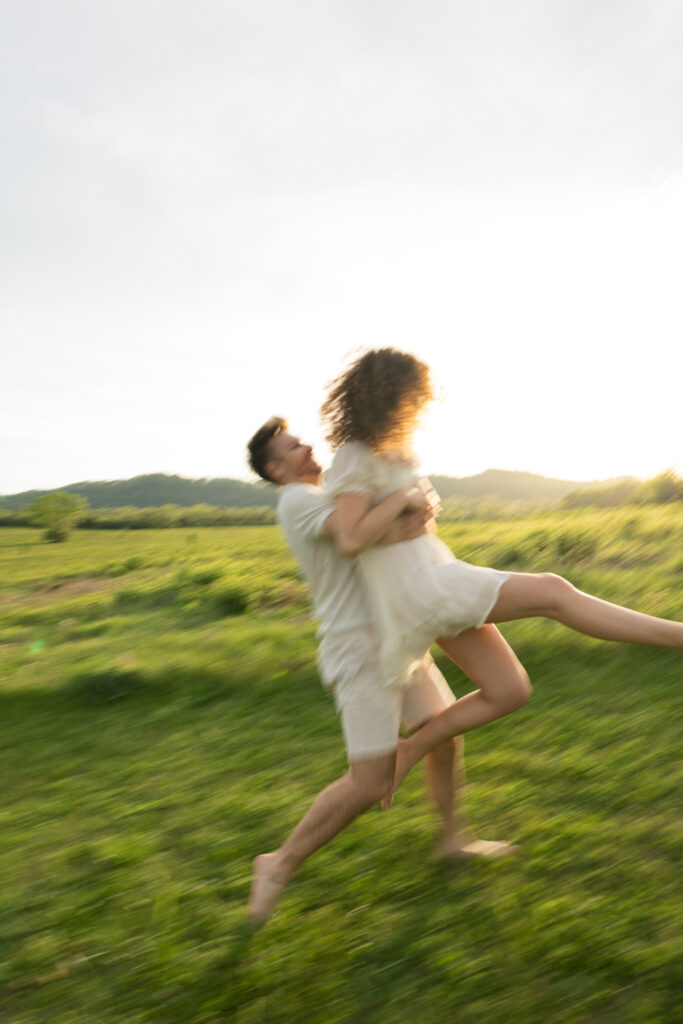 Couple playing tag during engagement session at Bells Bend 