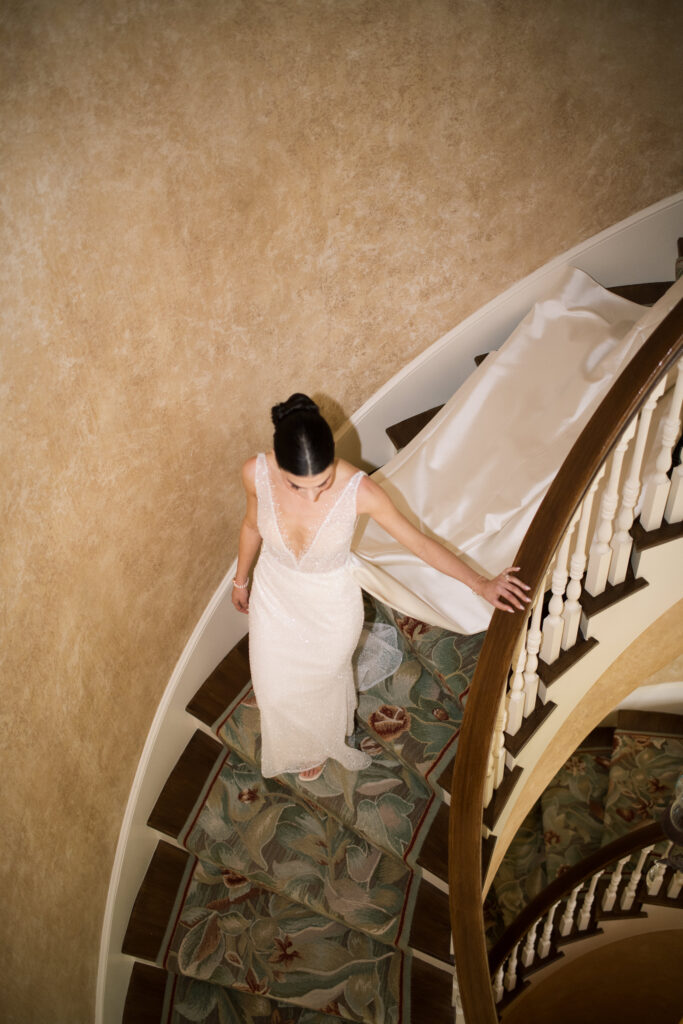 Bride walking down the stairs in the foyer at Cherokee Dock