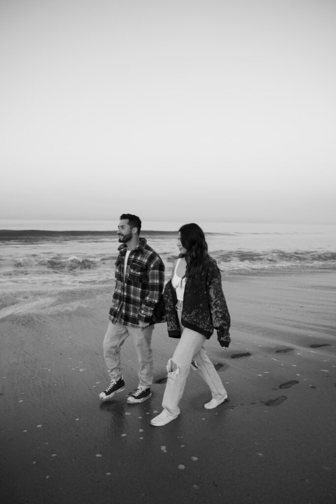 Couple walking on the beach at sunrise in Santa Monica, California