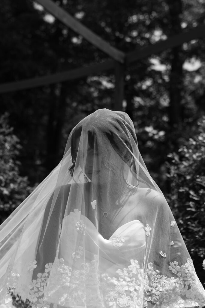 Bride posing in front of a hydrangea bush during her summertime wedding in Cincinnati, Ohio