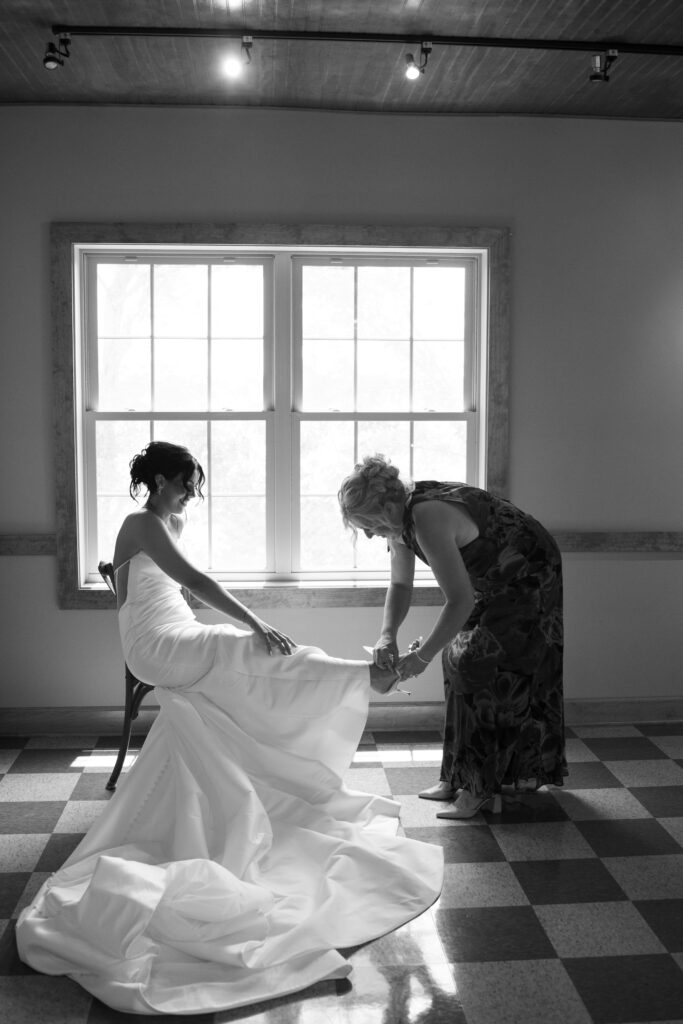 Mom helping her daughter get ready on her wedding day 