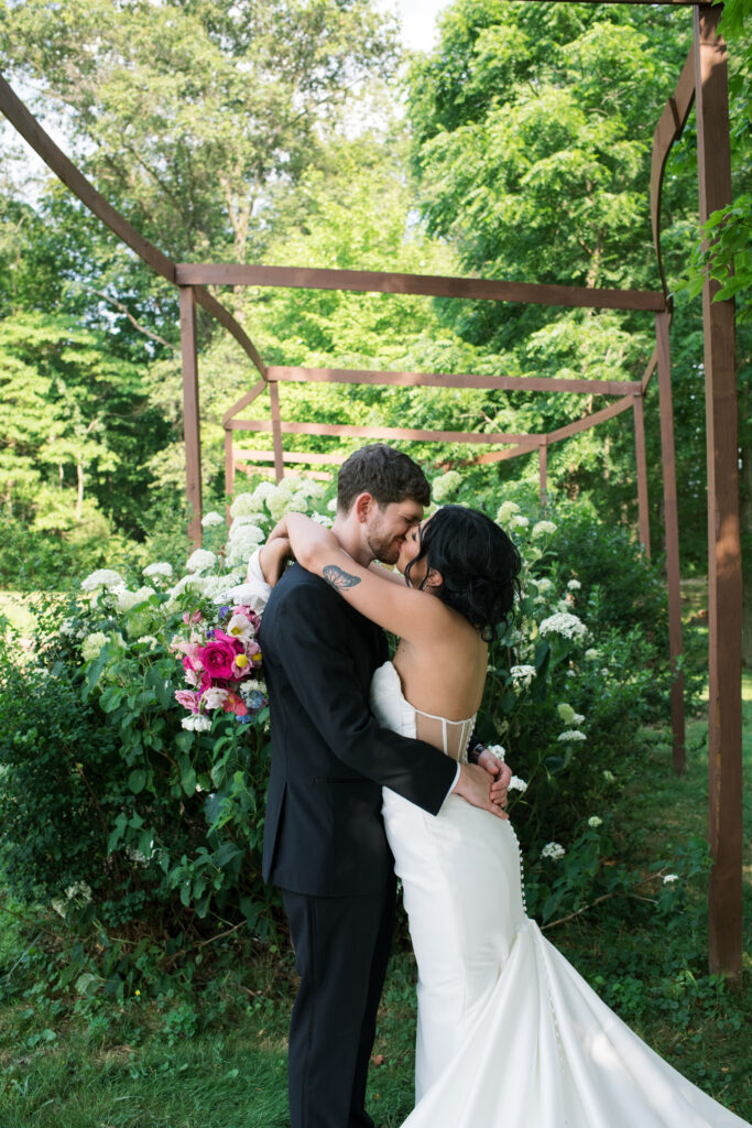 Bride and groom posing on a flower farm in Cincinnati, Ohio at their summertime wedding