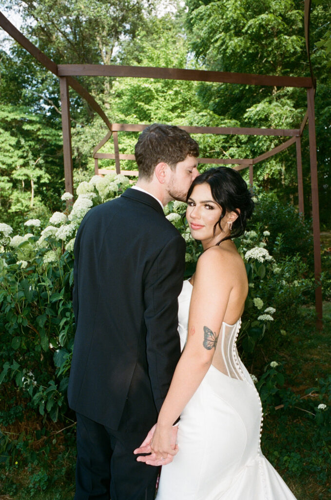 Bride and groom posing on a flower farm in Cincinnati, Ohio at their summertime wedding