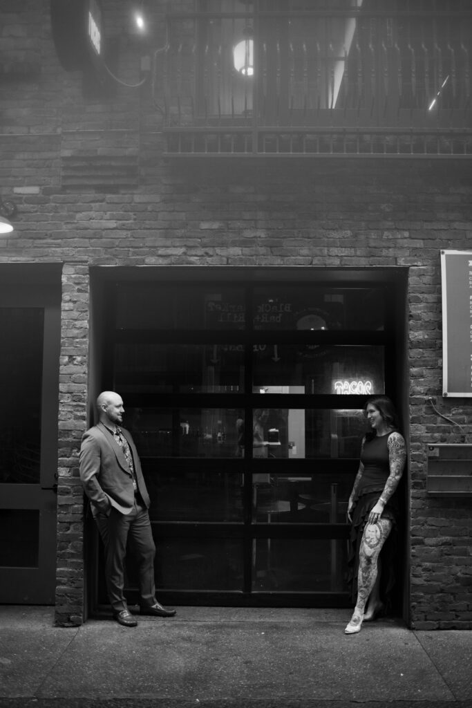 A black and white image of a couple posing in Printer's Alley in Nashville, Tennessee 