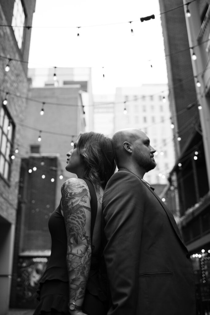 A black and white image of a couple posing in Printer's Alley in Nashville, Tennessee 