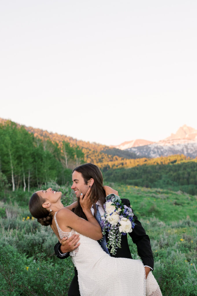 Couple laughing in front of the Grand Teton Mountains 