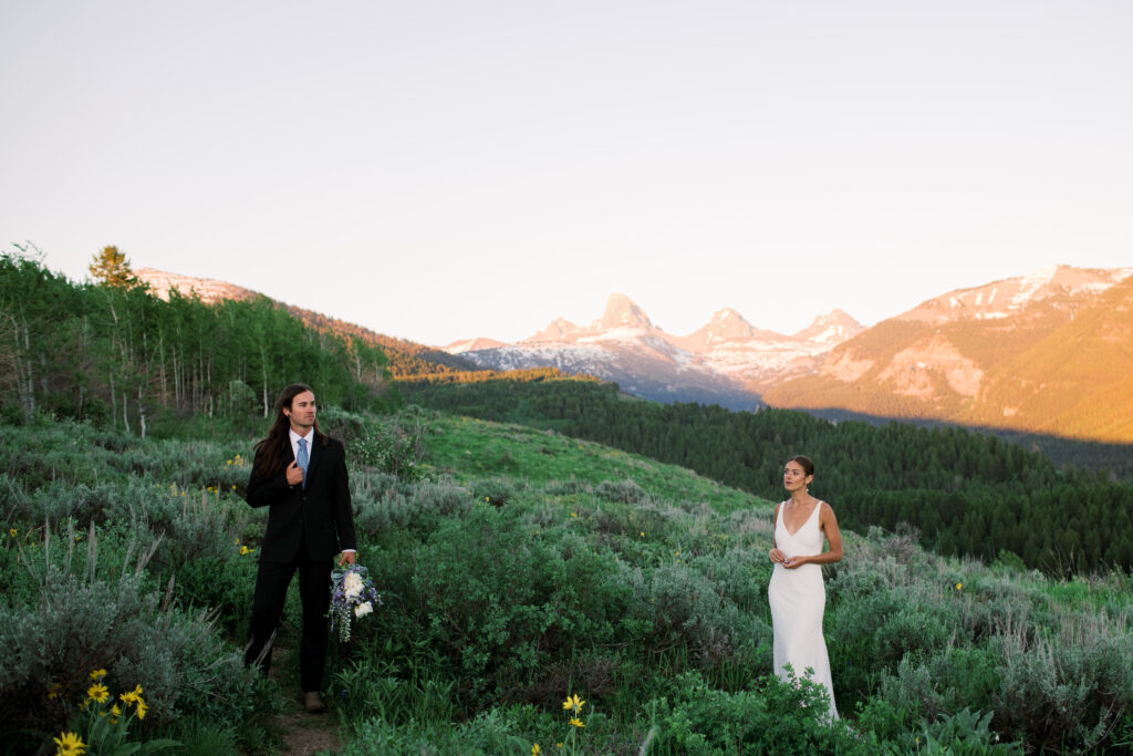 Couple posing at golden hour with Grand Teton National Park in the distance