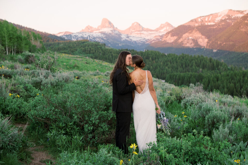 Couple posing at golden hour with Grand Teton National Park in the distance