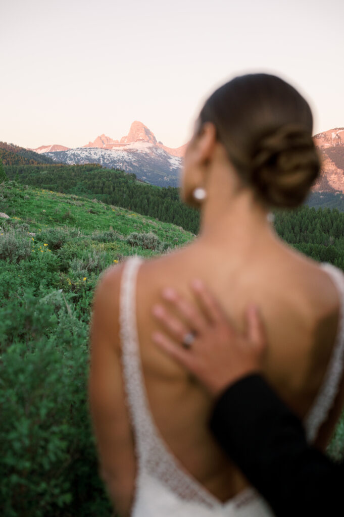 Couple looking into the distance with the Grand Tetons in focus