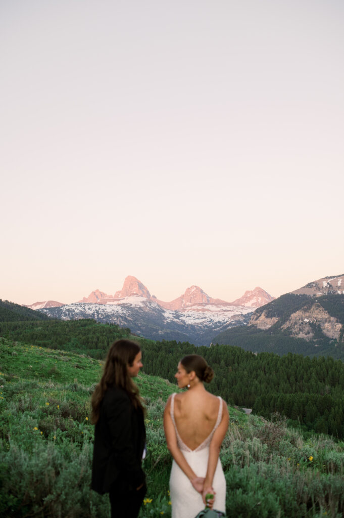 Couple posing at golden hour with Grand Teton National Park in the distance