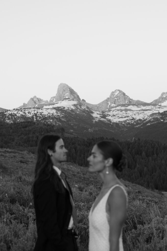 Couple posing at golden hour with Grand Teton National Park in the distance