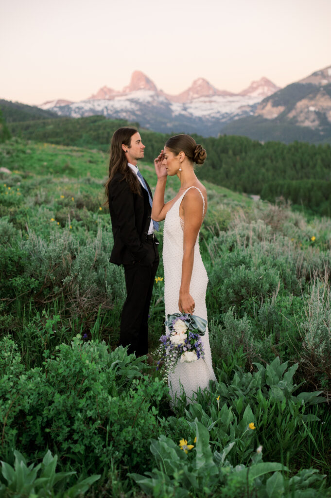 Couple posing at golden hour with Grand Teton National Park in the distance