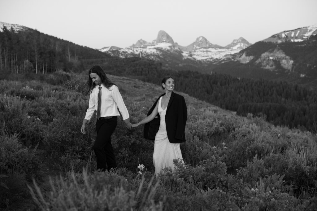 Couple posing at golden hour with Grand Teton National Park in the distance