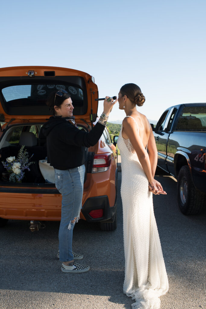 Black Fern Beauty Co. doing brides makeup outside of the car in Grand Teton National Park before her elopement 