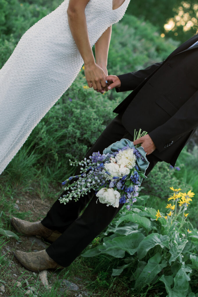 Detail photo of a brides bouquet that is white, blue, and purple 