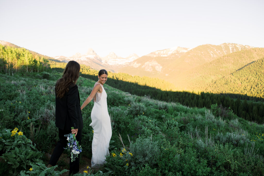 Couple walking down the train in front of the Grand Teton Mountains