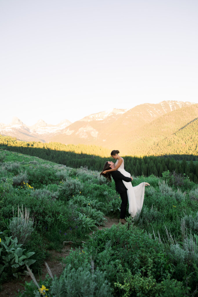 Couple walking down the train in front of the Grand Teton Mountains